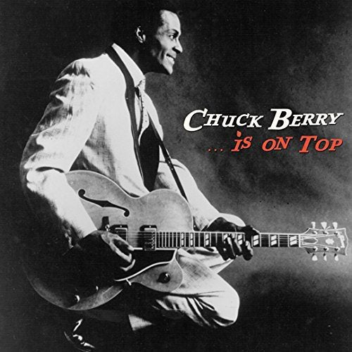 Black and white photo of Chuck Berry playing an electric guitar.
