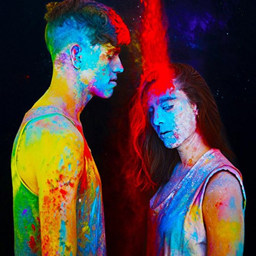 Two people facing each other, covered in vibrant colored powder.