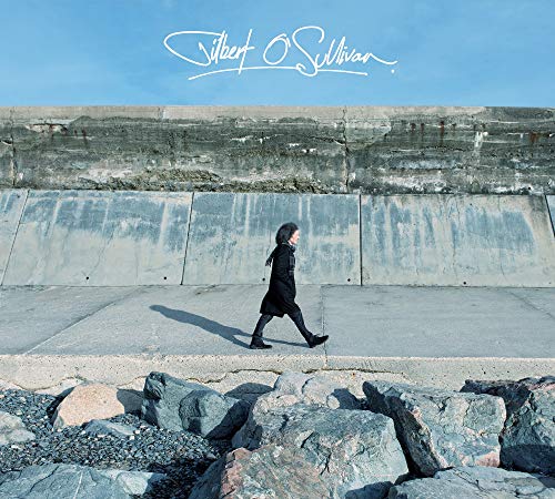Album cover: a lone figure walks along a concrete seawall.