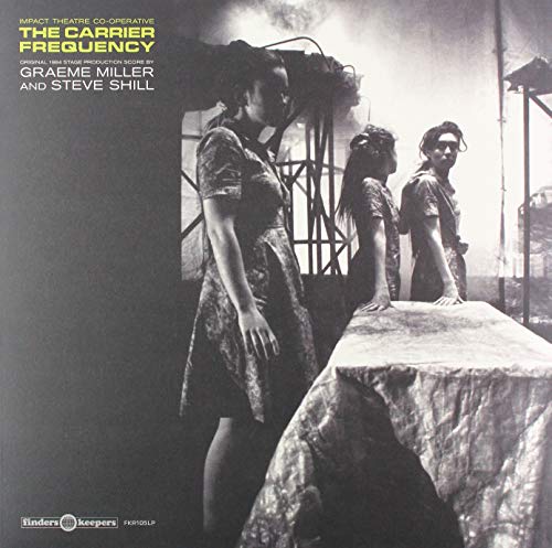 Vinyl record cover: three figures stand before a blurred, industrial scene.