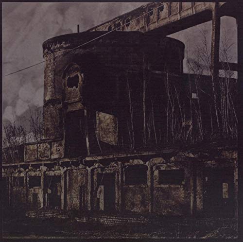 Dark, grainy image of an abandoned train car and industrial landscape.