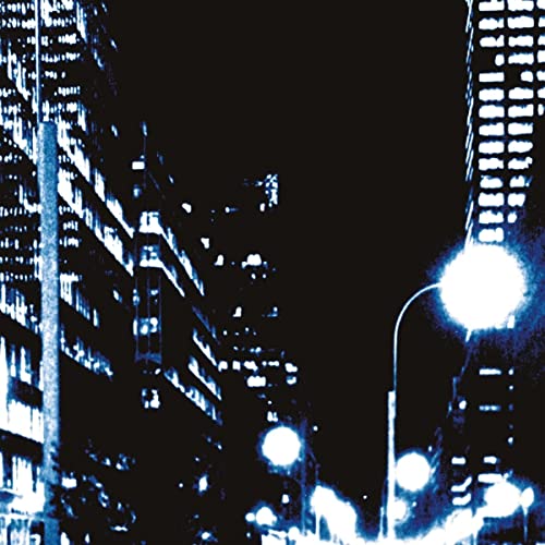 Night cityscape with illuminated buildings and streetlights, blue tint.