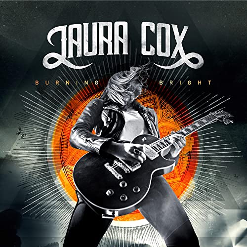 Laura Cox playing a black electric guitar against a bright orange sunburst.