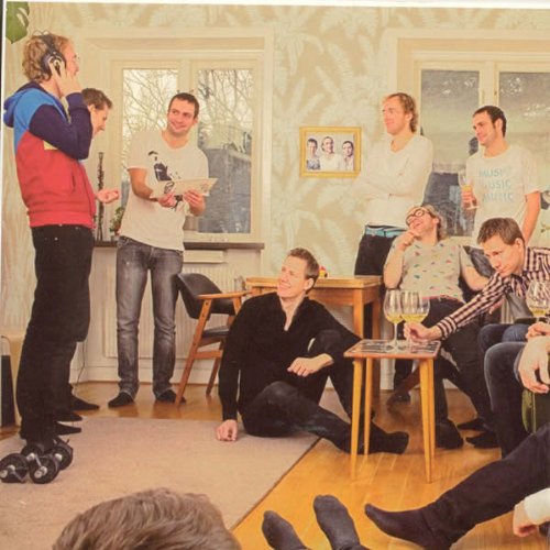 Group of casually dressed people gathered in a brightly lit room.