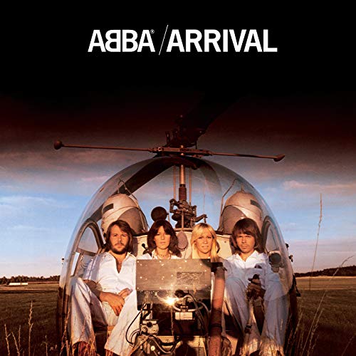 The four members of ABBA sitting inside a helicopter cockpit against a sunset sky.