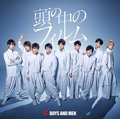 Group of eight young men in white uniforms posing against a blue background.