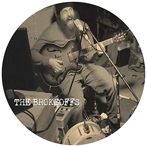 Black and white photo of a bearded musician playing guitar.