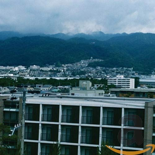 CD cover with a blurred landscape of mountains and a town.