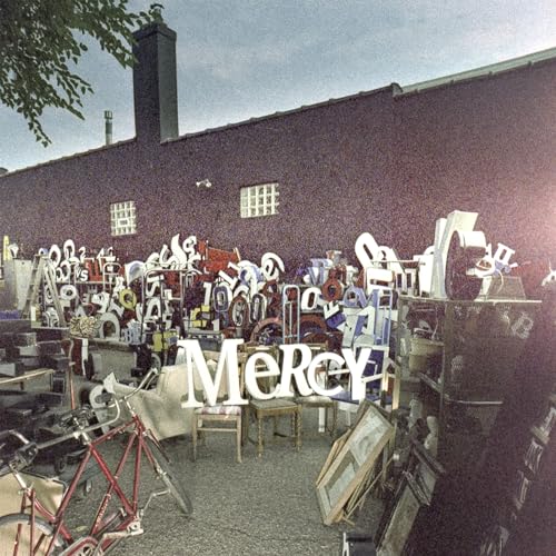 Vinyl album cover for “Mercy” featuring a building and scattered objects.