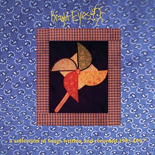 CD cover: colorful pinwheel on patchwork quilt, blue floral background.