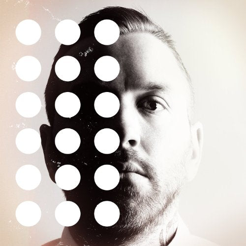 Black and white portrait of a man partially obscured by white circles.