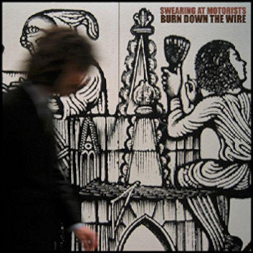 A blurry person stands before a black and white illustration of medieval figures.