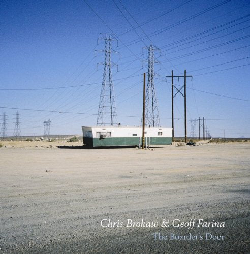 Desert landscape with a small building and multiple power lines.