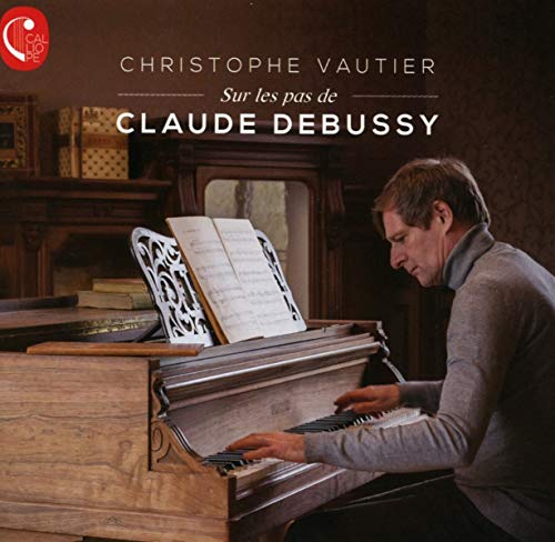 Pianist Christophe Vautier at an antique piano with sheet music.