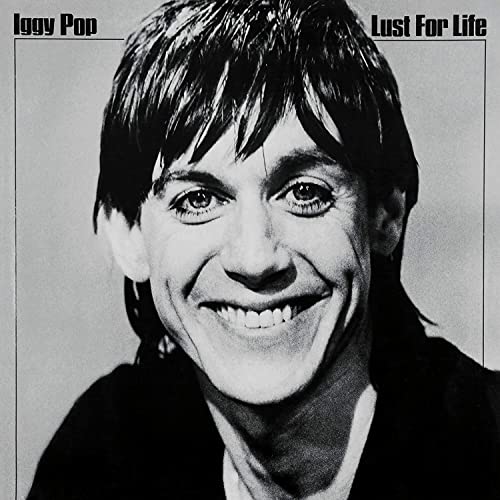 Black and white portrait of Iggy Pop, smiling, for the album Lust For Life.