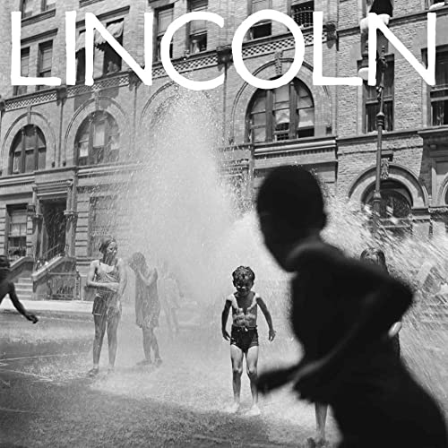 Black and white photo of children playing in a water fountain.