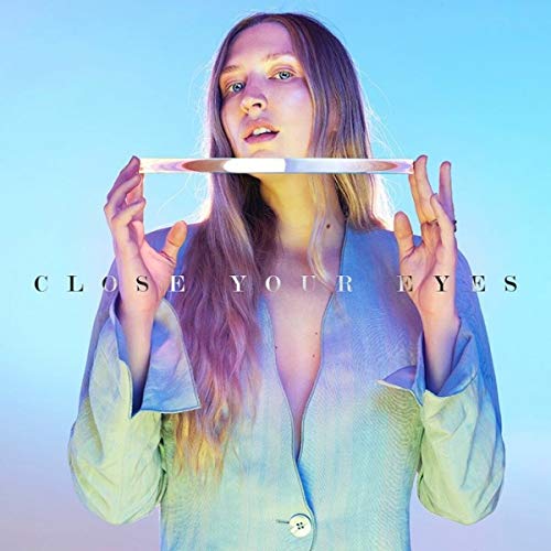 Woman with long hair holding a glowing blade, album cover art.