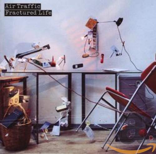 CD cover showing a cluttered room with a table, chair, and electronic equipment.