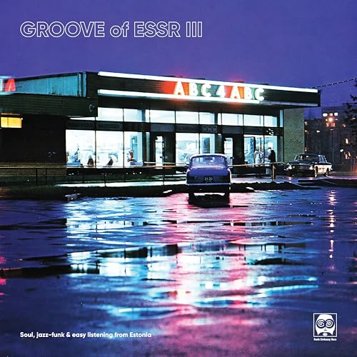 Vinyl record cover: storefront with cars reflected in a wet pavement.