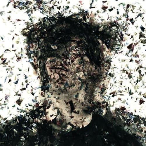 Close-up of a person’s face obscured by fragmented, colorful pieces.