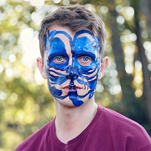 Man with blue paint covering his face, looking at the viewer.