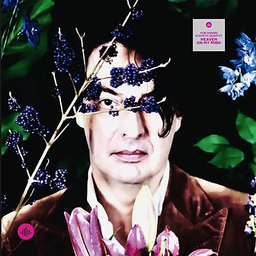 Album cover featuring a man with flowers and berries obscuring his face.