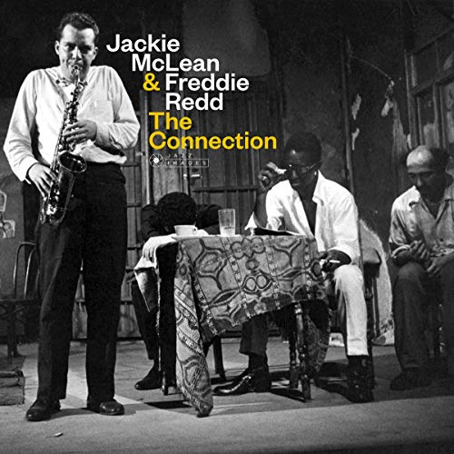 Black and white photo of Jackie McLean playing saxophone with Freddie Redd and others.