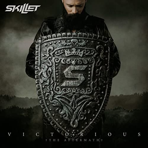 A man in a leather jacket holds a large, ornate shield with an S logo.