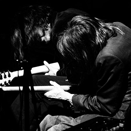 Black and white photo of two musicians playing instruments.