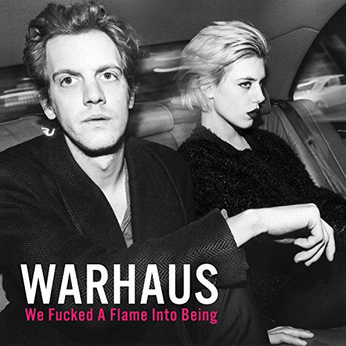Black and white portrait of two people in a car interior, album cover.