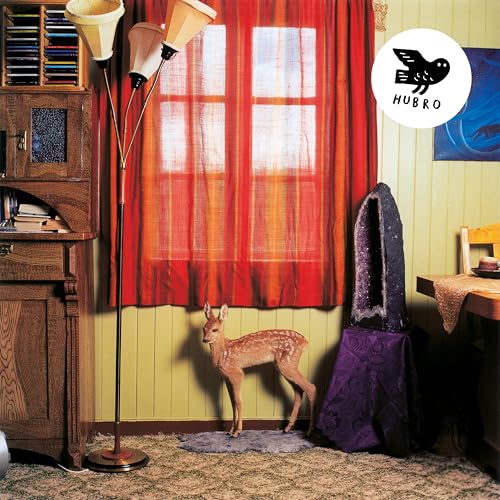 CD cover: deer standing in a room with red curtains and lamps.