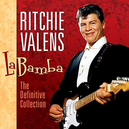 Ritchie Valens in a black jacket and white shirt holding an electric guitar.