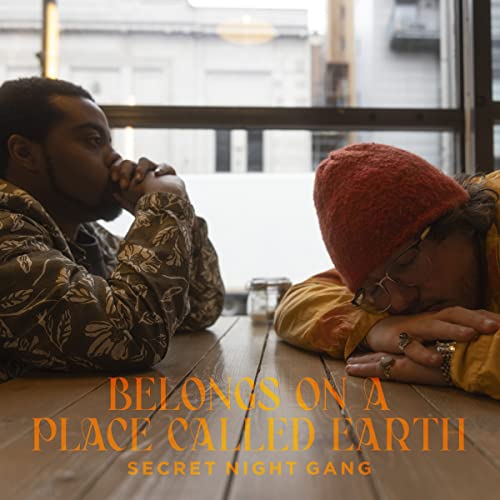 CD cover featuring two people with heads bowed, text āBelongs On A Place Called Earthā.