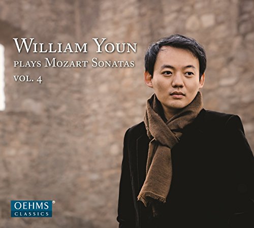 William Youn wearing a brown scarf against a blurred stone wall background.