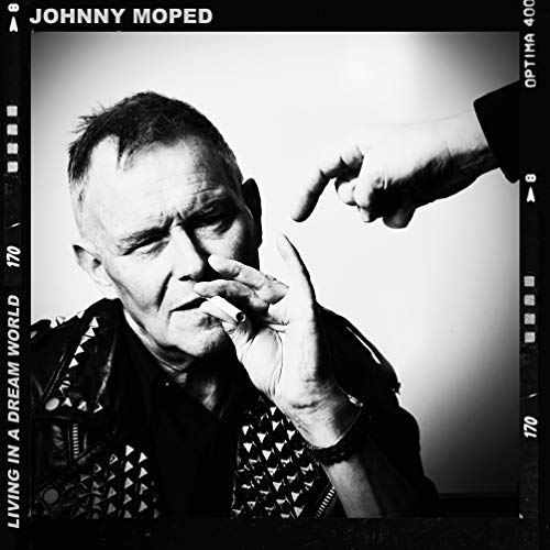 Black and white portrait of a man smoking, wearing a studded jacket.