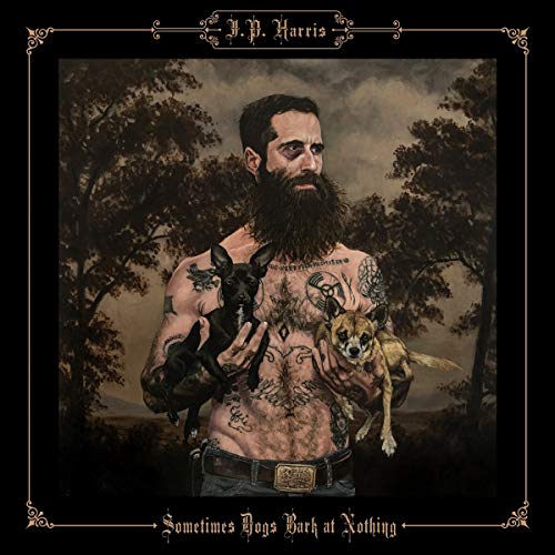 Portrait of bearded man with tattoos, holding two small dogs.