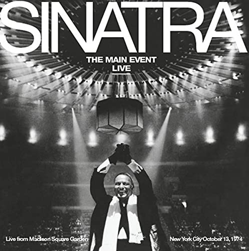 Frank Sinatra in a tuxedo with a hat, performing on stage.