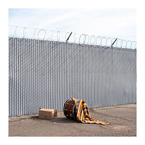 CD cover: drum and colorful fabric leaning against a chain-link fence.