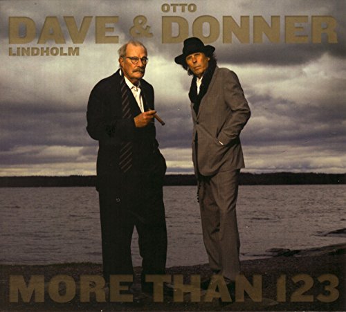 Two men in suits stand before a cloudy waterscape.