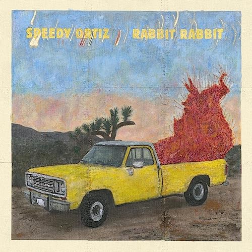 Album cover: yellow truck with fiery cargo in a desert landscape.