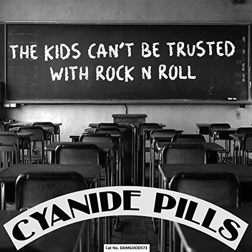 Black and white classroom with a chalkboard reading "The Kids Can't Be Trusted With Rock N Roll".