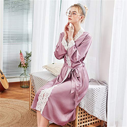 Woman in pink robe sitting on wicker bench by window with white curtains.