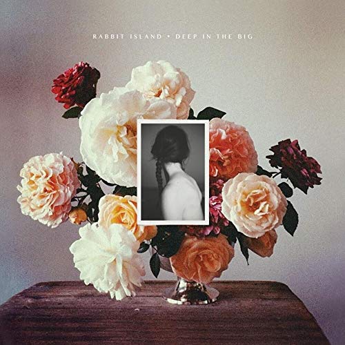 Album cover with flowers surrounding a black and white portrait.