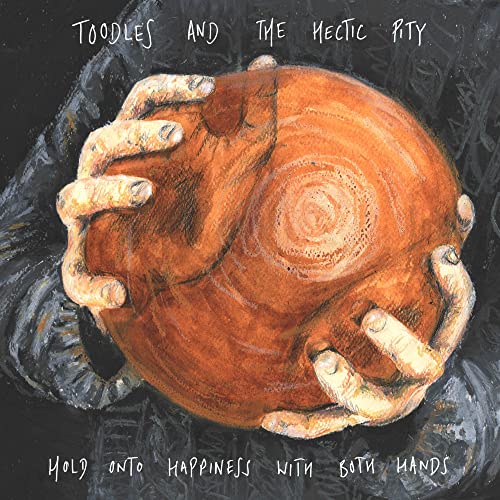 Painted hands cradling a round, wooden object with a swirling grain.