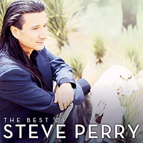 Steve Perry in a dark blazer, looking away from the camera near desert plants.