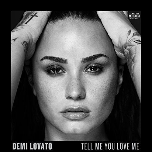 Black and white portrait of Demi Lovato with hands on head.
