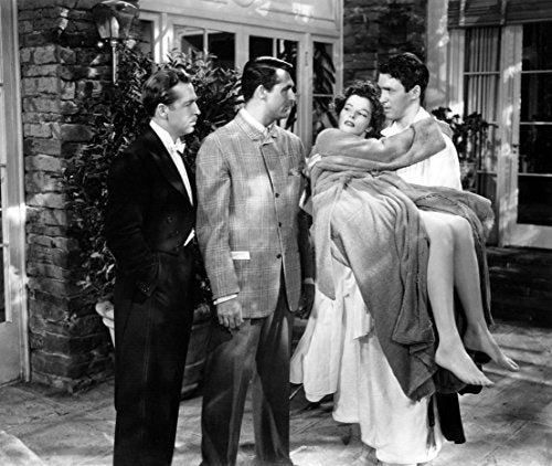 Black and white film still: men carrying a woman outdoors.