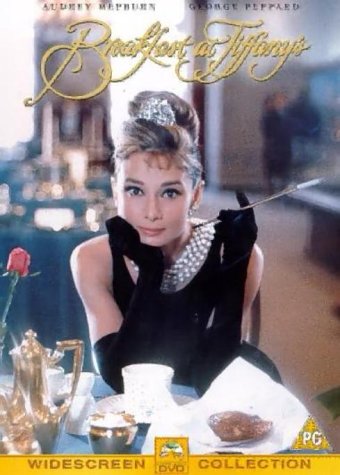Audrey Hepburn wearing a black dress, pearls, and tiara while holding a cigarette holder.