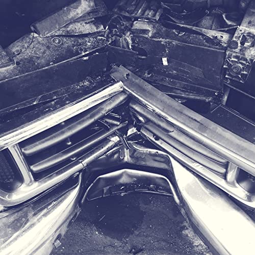 Crushed metal and chrome of a heavily damaged vintage car front end.