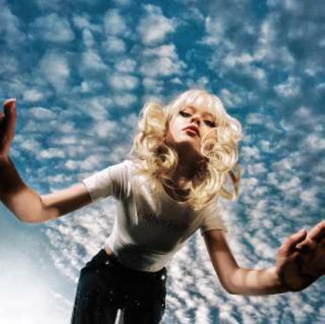 Maisie Peters album cover: blonde woman against a cloudy blue sky.